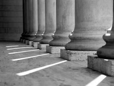 Black and white photo of stone pillars in front of court house