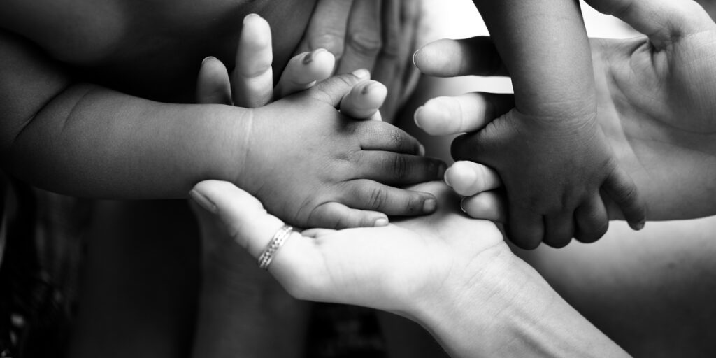 A parent holding hands with her children.