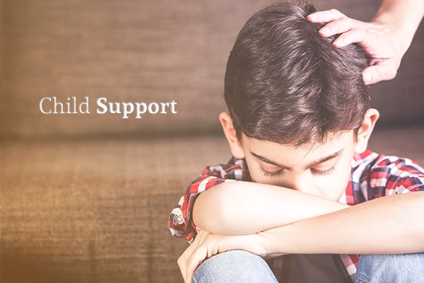 A picture of a child looking dejected, his head down, arms crossed over his knees, with a comforting hand on his head beside the words "Child Support"