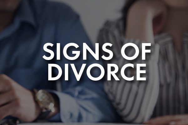 A couple walking intensely with the words, "Signs of Divorce"